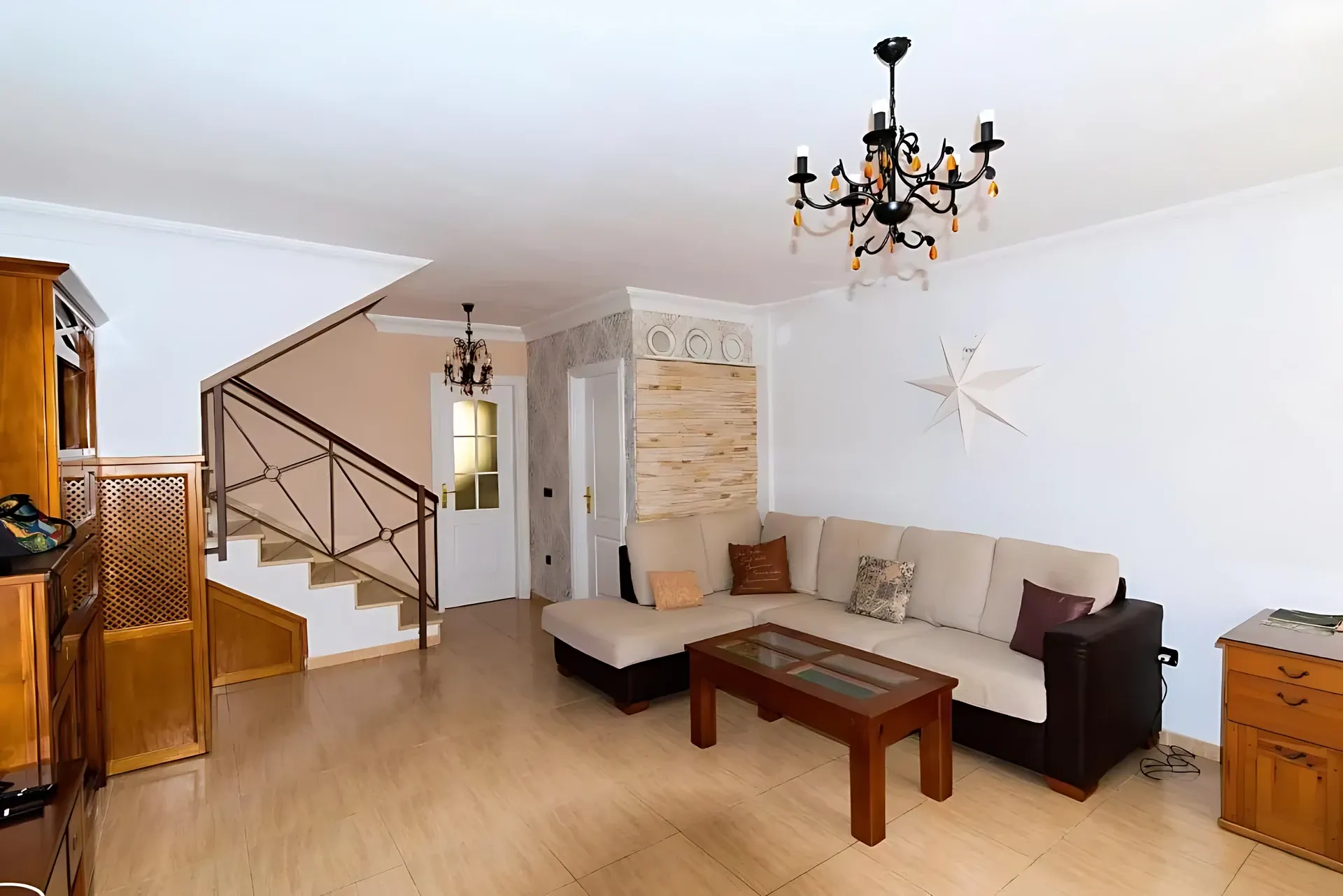 Salón con sofás, mesa de centro y escalera de madera