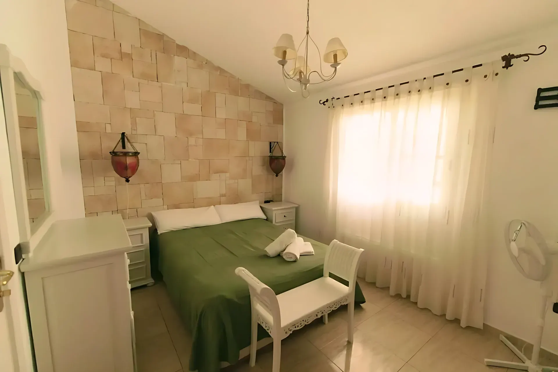 Dormitorio con cama doble y ventana con cortinas