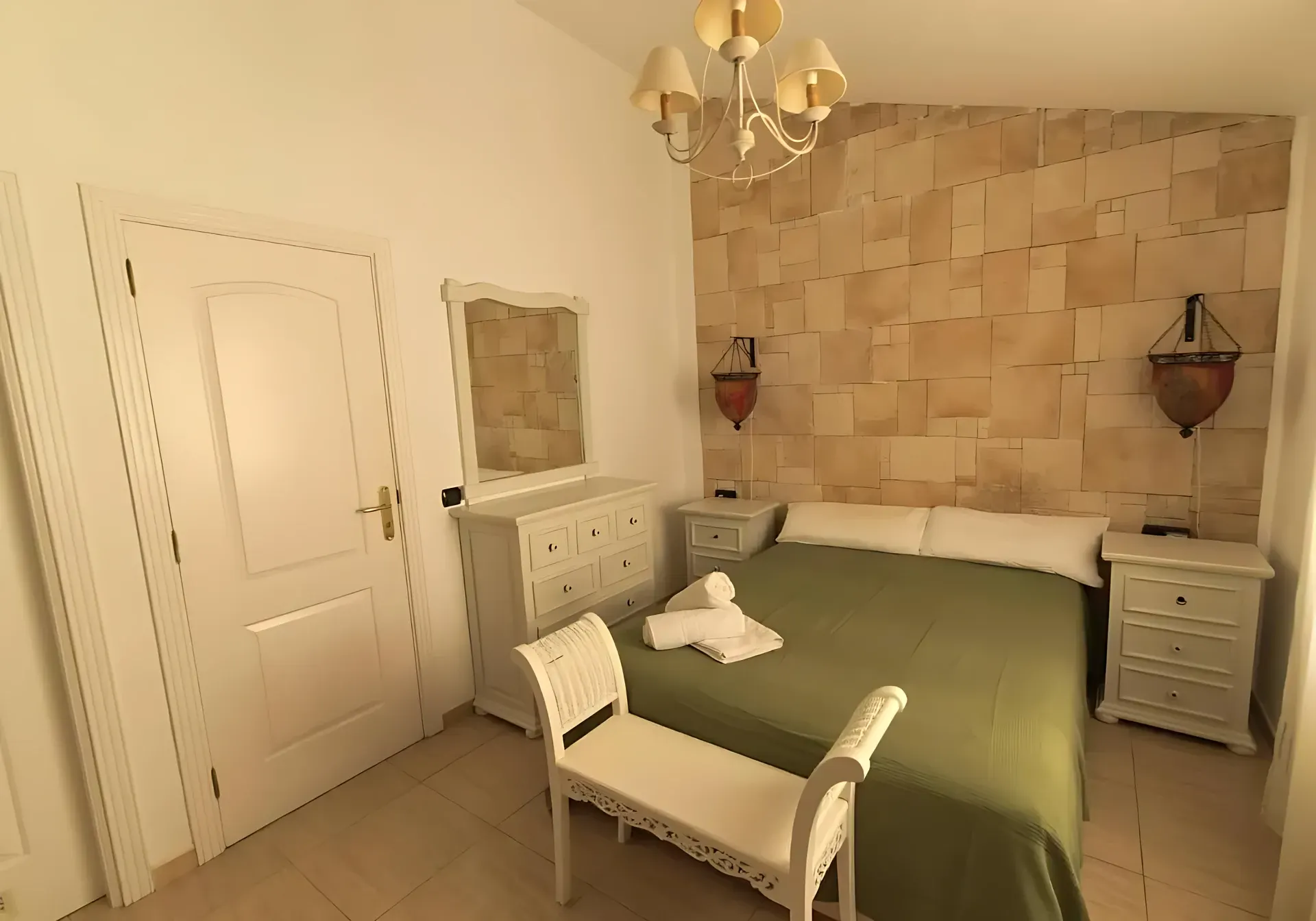 Dormitorio con cama vestida en verde y mesitas de noche
