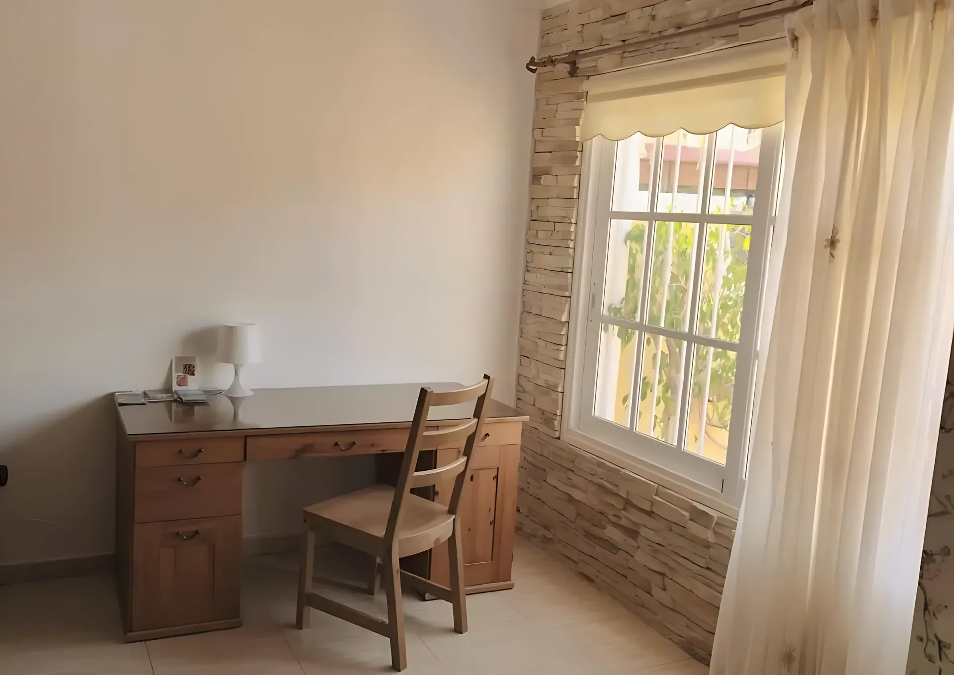 Rincón de trabajo con escritorio junto a la ventana